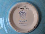 a blue and white plate with a crest on it