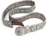 une vieille ceinture avec une boucle métallique sur fond blanc