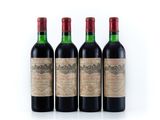 three bottles of red wine sit next to each other on a white surface