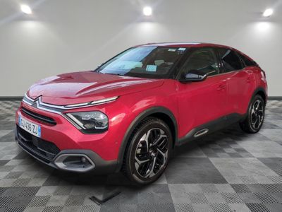 une voiture rouge garée dans un garage au sol en damier