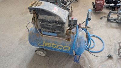 a small air compressor sitting on the floor in a room