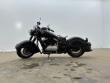 a black motorcycle parked in a garage with a white wall