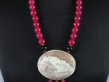 une femme portant un collier orné d'une pièce de monnaie et de perles rouges