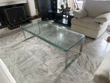 a glass coffee table in the middle of a living room