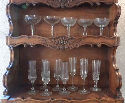 a wooden shelf with wine glasses on top of it