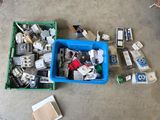 une boîte bleue remplie d'objets divers, posée par terre