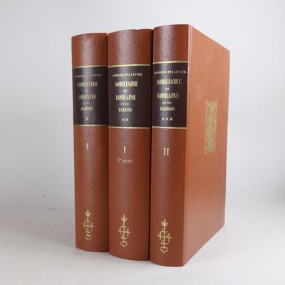 three books are sitting on a white surface, one is brown and the other is black