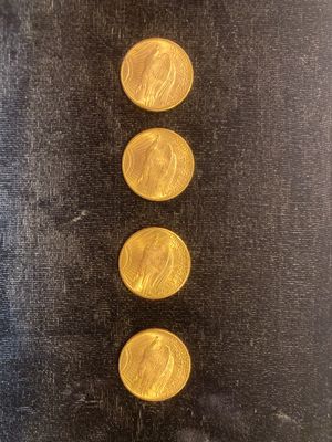un gros plan sur trois pièces d'or posées sur une surface noire