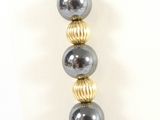 a close up of a silver and gold bead necklace