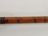 a wooden pipe with a clock on it on a white surface
