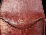 a close up of a red leather bag with a gold logo on it