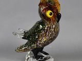 a glass figurine of an owl with a crown on it ' s head