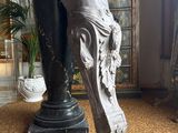 a statue of a woman holding a vase in a room