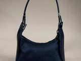 a black guccissi bag with a gold buckle on the handle