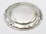 an antique silver plate with a flower design on it