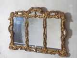 a gold mirror hanging on the wall next to a white wall