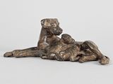 statue en bronze représentant un chien couché sur le dos sur une surface blanche