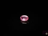 un diamant rose sur une surface noire