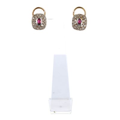 une paire de boucles d'oreilles en diamants roses et blancs, posée sur un présentoir
