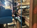 a blue chair in the middle of a room filled with furniture