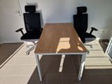 two black office chairs sitting next to a wooden table