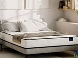 un lit sur lequel est posé un matelas dans une pièce