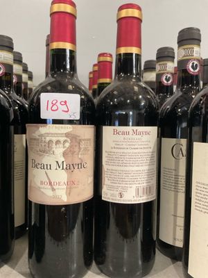 plusieurs bouteilles de vin rouge sont alignées sur une étagère