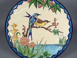 une assiette décorative ornée d'un oiseau et de fleurs