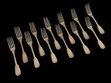 six forks are lined up in a row on a black background