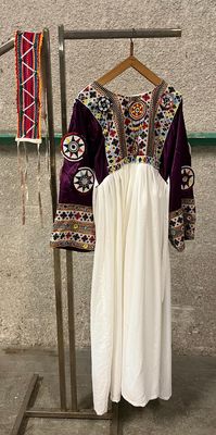 a dress hanging on a clothes rack in front of a wall