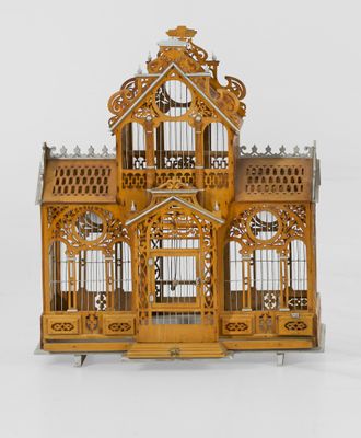 une petite cage à oiseaux en bois surmontée d'une horloge