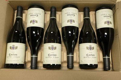 six bouteilles de vin dans un carton sur une table