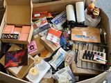une boîte en carton posée par terre et remplie d'objets divers
