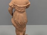 a small statue of a boy holding a bird on a pedestal