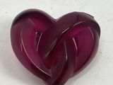 a purple heart shaped object sitting on a white surface