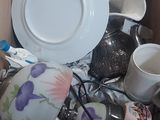 a box full of tea cups and saucers and a plate