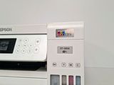 a white printer sitting next to a printer on a table