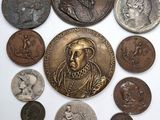 une image représentant un ensemble de pièces de monnaie sur lesquelles figurent un homme et une femme