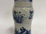 un gros plan d'un vase posé sur une surface blanche, orné de motifs bleus et blancs