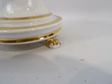 a white and gold plate with a gold stripe on it