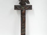 une croix en bois surmontée d'un oiseau, sur fond blanc
