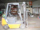 a forklift in a warehouse with a lot of equipment