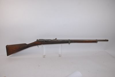 un fusil avec un canon en bois sur une surface blanche