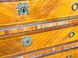 a wooden chest of drawers with brass hardware on the drawers