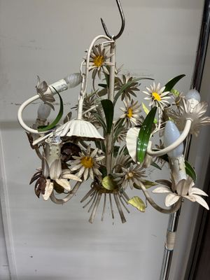 un lustre blanc auquel est suspendu un bouquet de fleurs