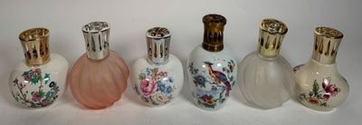 several different types of perfume bottles are lined up on a white surface