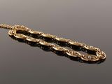 an image of a pair of gold and black beads on a black surface