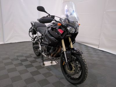 une moto qui est garée dans une pièce dont le sol est en damier