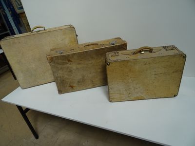 three old suitcases are sitting on a table in a room
