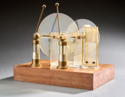 une petite maquette de machine à vapeur posée sur un socle en bois